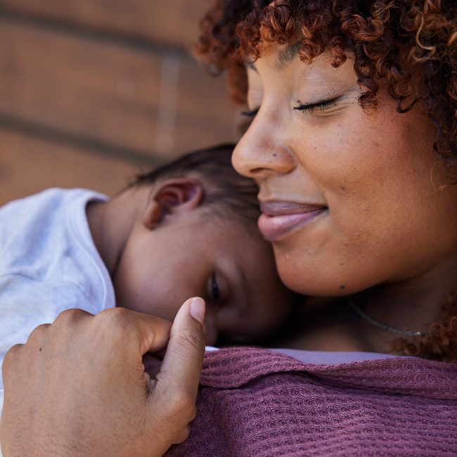 A mother holding her baby and smiling