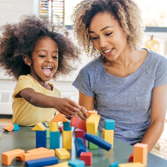 A mother with her child who is playing with colorful blocks