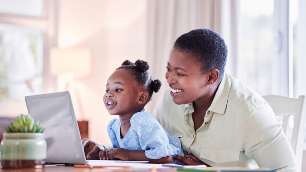 Shot Of A Young Woman Working While Caring For Her Adorable Baby Girl At Home